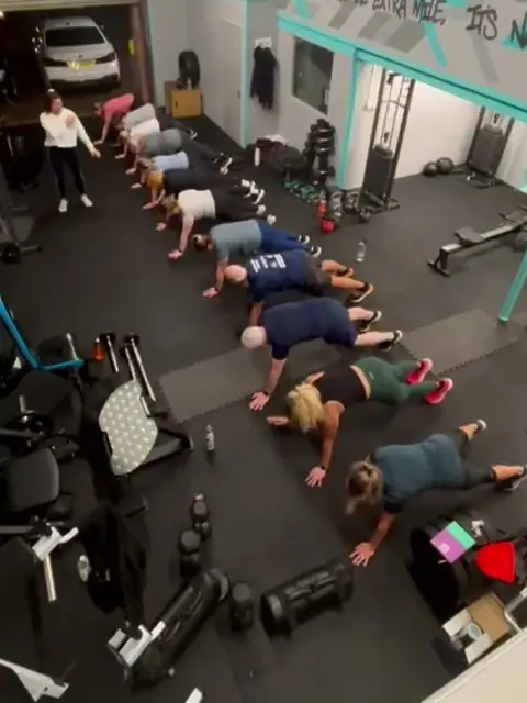 A Let Luce class doing press-ups in a line on the studio floor at Unit 49, seen from above.
