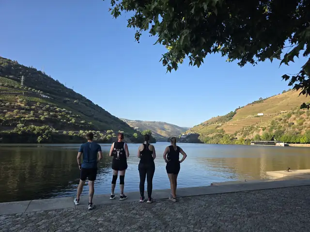 A Let Luce group standing at the river&rsquo;s edge in the Douro Valley, looking out at the hills.