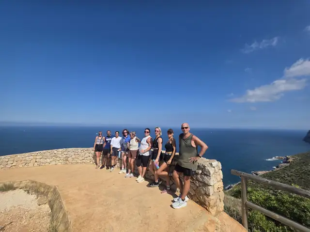 A Let Luce retreat group at a clifftop viewpoint above the sea.