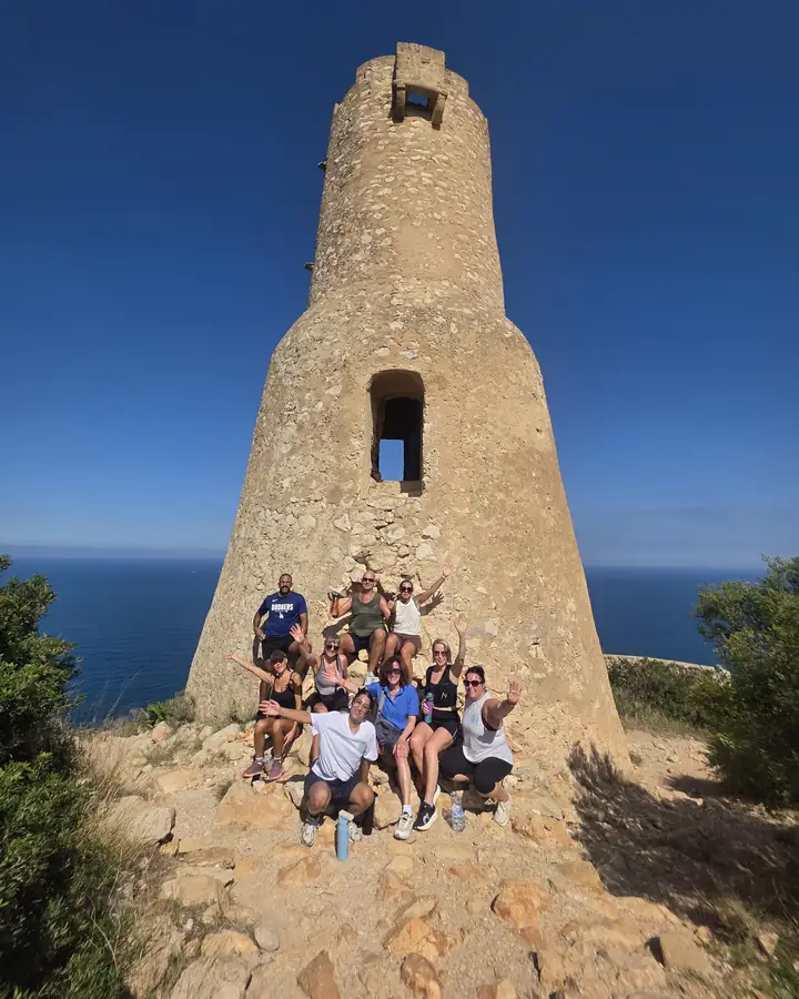 The retreat group gathered at the foot of an old stone watchtower above the sea.