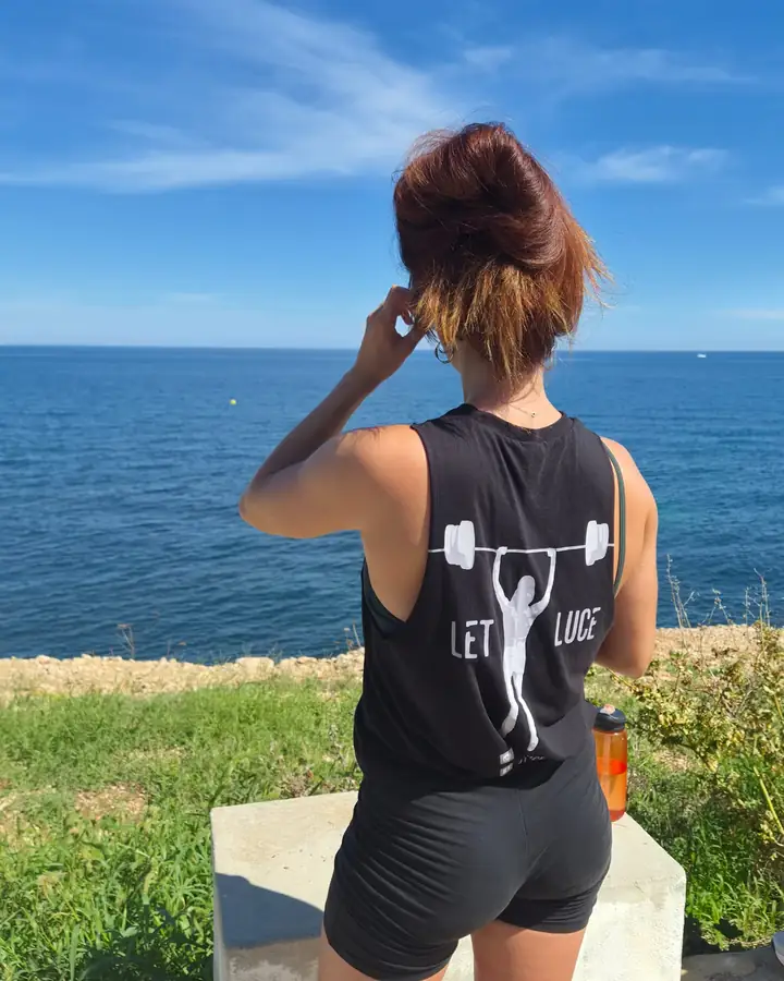 A woman in a Let Luce vest looking out over the blue sea.